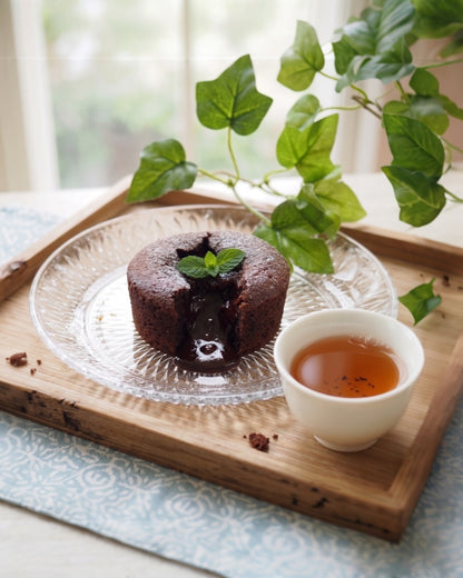 Thé hojicha Shôbi accompagné d'un fondant au chocolat, accord mets-thé sur plateau en bois avec feuillage