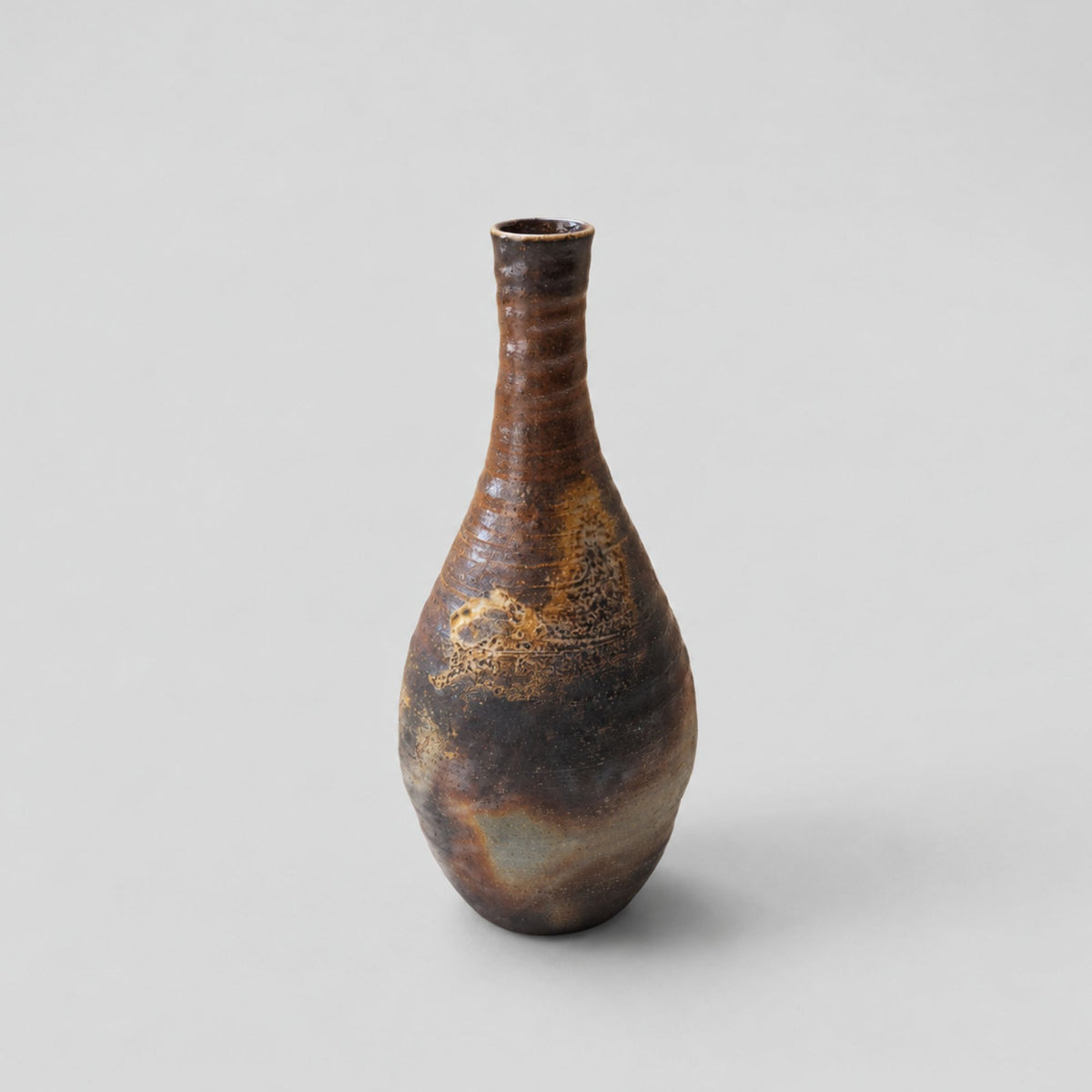 Vase japonais en céramique de Bizen par Sueishi Kōsen, aux nuances brunes et ambrées, avec un col étroit et une forme élancée.